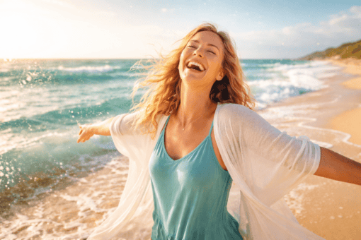 Joy Let loose woman in turquoise dress laughs on beach with arms outstretched